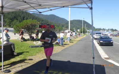 Dr. Derek Larsen crossing the finish line at the Juneau Alaska Marathon