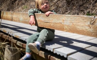 Child sitting on a bridge representing pediatric chiropractic care at Happy Family Chiropractic in Juneau Alaska